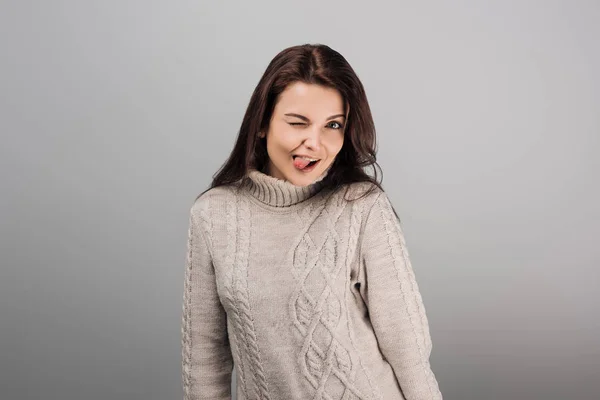 Cheerful woman sticking out tongue isolated on grey — Stock Photo
