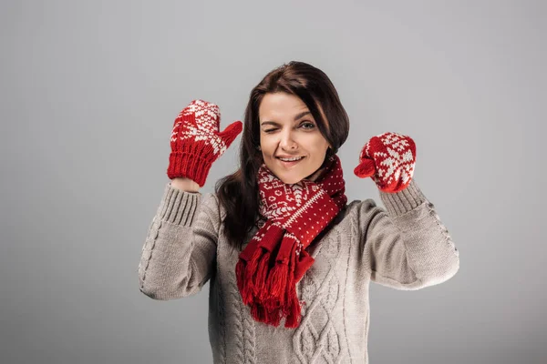 Жінка в червоних рукавичках і очі, що підморгують, ізольовані на сірих — стокове фото