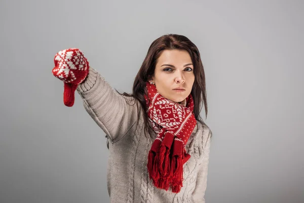 Незадоволена жінка в червоних рукавичках і шарфі з великим пальцем ізольований на сірому — стокове фото