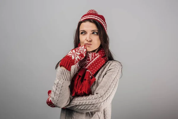Mujer pensativa en punto rojo tenía, guantes y bufanda aislados en gris - foto de stock