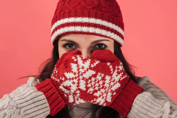 Mujer en la cara cubierta sombrero de punto con guantes rojos y cálidos aislados en rosa - foto de stock