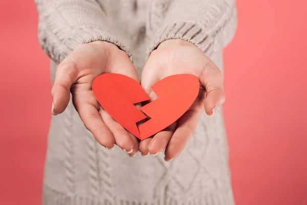Cropped view of woman in sweater holding paper cut with broken heart on pink — Stock Photo