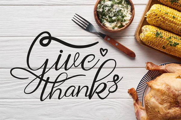 Top view of turkey and corn served at white wooden table with give thanks illustration — Stock Photo