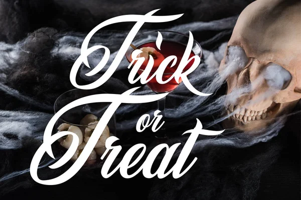 Gruseliger menschlicher Totenkopf in roter Beleuchtung, Halloween-Dekoration mit Trick oder Leckerbissen — Stockfoto