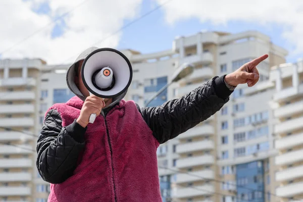 Bir adam bir ağızlık ile yönünü gösterir. Bir sokak organizatörü eseri. Moskova, Rusya, 2018 31 Mayıs