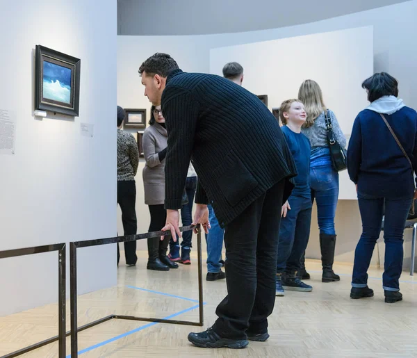 Moskova, Rusya - 16 Şubat 2019. Adam sanat galerisindeki resmi dikkatle inceliyor.