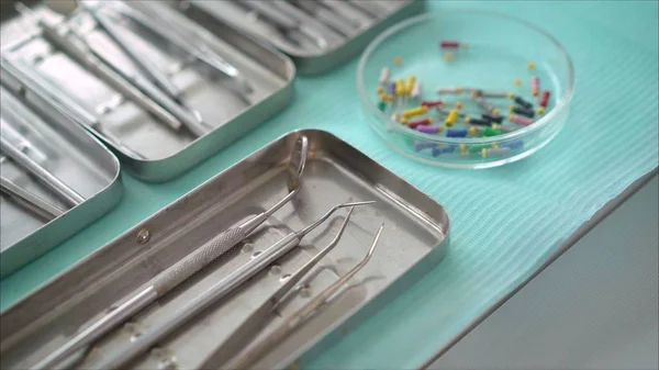 Steel dental instruments, mirror, on a blue background. Dental instruments.