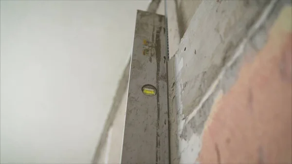 Wall alignment with a special tool. Alignment of walls in the repair with the help of a special device level. Close up — Stock Image Wall Alignment Special Tool Alignment Walls Repair Help Special Device Stock Photo