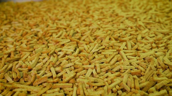 Croutons on the conveyor. Finely chopped brown bread crumbs. A bunch of brown spicy pieces of rusk. View from above. Close-up — Stock Image Croutons Conveyor Finely Chopped Brown Bread Crumbs Bunch Brown Spicy Royalty Free Stock Images