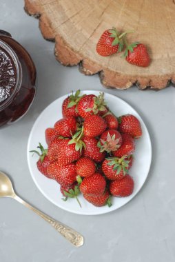 Çilek reçeli ve taze çilek dokulu Grau arka plan çimento