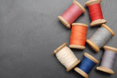 Rulo, Vintage renkli iş parçacıklarını kapatın. Giysi onarım, siyah koyu arka plan. İş dikiş