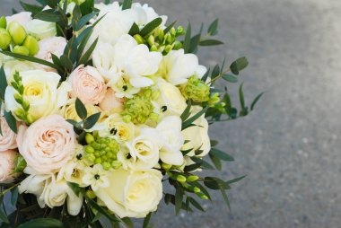 Beyaz düğün buket gül pembe çiçekler ve Ruscus yaprakları gri asfalt zemin üzerine Robbons ile.
