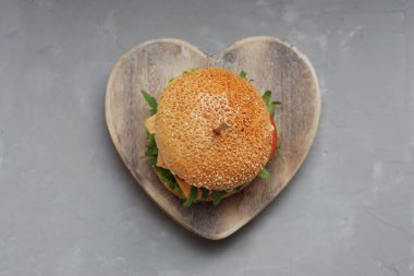 Fast food. Vejetaryen ev yapımı Hamburger peyniri, salatalık, domates ve marul, salata. Taze sebze öğle yemeği için lezzetli sandviç. Gri arka planı