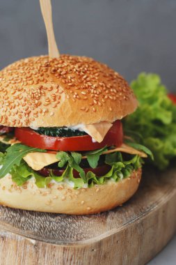 Fast food. Vejetaryen Homenade Burger salatalık, domates ve marul, salata. Taze sebze öğle yemeği için lezzetli sandviç. Dokulu gri