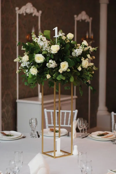 Beautiful White and Green Flower Decoration Arrangement on Wedding Table Golden Support .