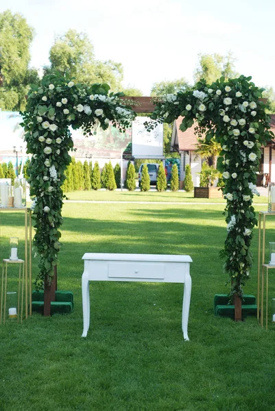 Rustic Wedding Ceremony Arch on the Open Area with Greem Grass.