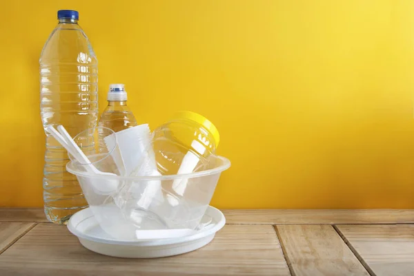 Plastik geri dönüşüm kavramı Whitel plastik yemekleri tabak bardak kaşık Isoalted sarı arka plan