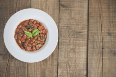 Kırmızı fasulye, domates soslu ıspanak ve soğan, beyaz yuvarlak tabak Meksika yemeği, kopya alanı ile pişmiş.