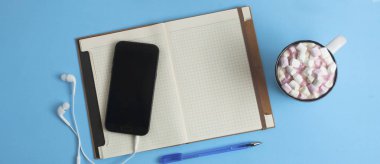 Çalışma alanı cep telefonu, Notebook, kahve öğrendiklerinde mavi arka plan,