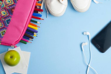 Geri okul, pembe durumda, öğle yemeği sandviç ve yeşil elma, renkli kalemler ve kopya alanı ile mavi arka plan için. 