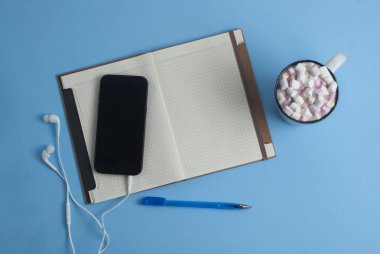 Çalışma alanı cep telefonu, Notebook, kahve öğrendiklerinde mavi arka plan.