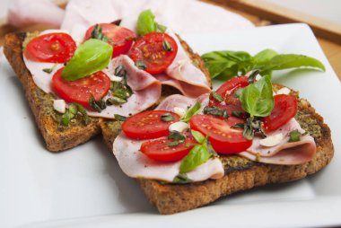 Sağlıklı ekmek tost pesto sos, domates, sarımsak ve fesleğen yaprakları.