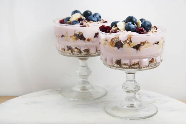 两个玻璃燕麦燕麦餐 蓝莓和酸奶 Isoalted 在白色背景下切大理石板的研究 — 图库照片