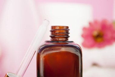 Güzellik spa kozmetik, salon tedavi kavramı. Pembe bir arka plan üzerinde cam Kozmetik şişe.