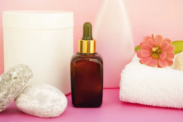 Beauty spa cosmetics, salon therapy concept. Glass cosmetic bottle on pink background.