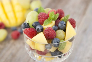 Cam - ahududu, mango, yaban mersini, üzüm, nane yaprakları lezzetli meyve salatası