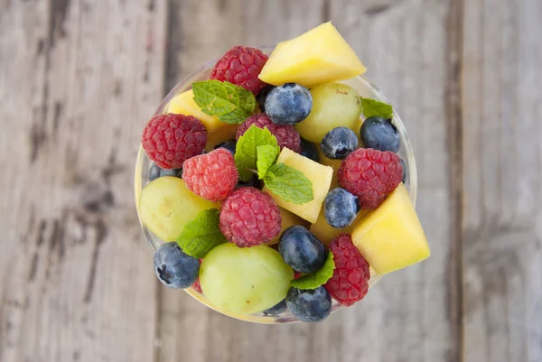 Salada Frutas Deliciosa Vidro Framboesa Manga Mirtilo Uvas Folhas Casa — Fotografia de Stock