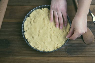 Holding ham ekşi hamur, temel pasta pasta, turta ya da kek için eller. Pan pişirme sağlıklı tatlı yemek. Rustik ahşap tablo. Üstten Görünüm.