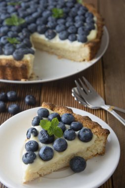 Sağlıklı tatlı. Böğürtlenli turta ya da pasta krema ile parçası. Taze tatlı tatlı meyve ile. Üstten Görünüm.