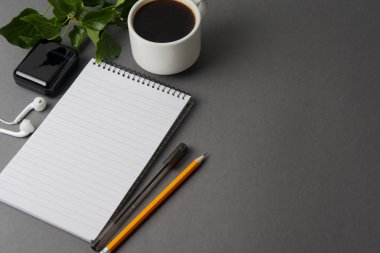 Çalışma Masası yaratıcı düz yatıyordu. Üstten Görünüm ofis büro dizüstü bilgisayarlar ve gri arka plan üzerinde kahve fincanı. Kopya alanı ile Üstten Görünüm.