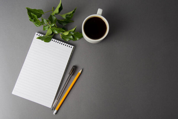 Creative flat lay of workspace desk. Top view office desk with notebooks and coffee cup on grey background. Top view with copy space.
