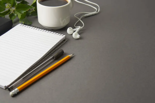 Creative flat lay of workspace desk. Top view office desk with notebooks and coffee cup on grey background. Top view with copy space.