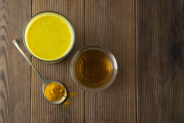 Zerdeçal altın süt. Sağlıklı içecek zerdeçal ve bal ile yaptı. Birçok hastalık için ilaç. Rustik ahşap arka plan.