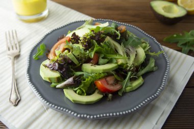 Sağlıklı salata karışımı buzdağı, ıspanak, avokado ve salatalık zeytinyağı, domates ve limon ile.