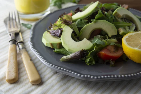 Sağlıklı salata karışımı buzdağı, ıspanak, avokado ve salatalık zeytinyağı, domates ve limon ile. — Stok fotoğraf