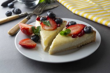 Cheesecake taze meyveleri ve tatlı - nane ile sağlıklı organik yaz tatlı pasta peynirli kek. Peynirli kek. Gri arka planı.