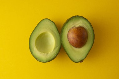 Sarı arka plan üzerinde izole olgun taze avokado slaces. Renkli sağlıklı gıda arka plan. Avokado izole. Kopya alanı.