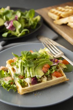Avokado ve domates ile Belçikalı Waffle. Sağlıklı yiyecekler için mükemmel kahvaltı veya kilo.