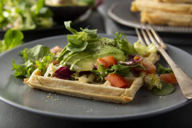 Avokado ve domates ile Belçikalı Waffle. Sağlıklı yiyecekler için mükemmel kahvaltı veya kilo.
