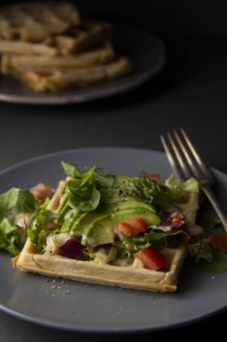 Avokado ve domates ile Belçikalı Waffle. Sağlıklı yiyecekler için mükemmel kahvaltı veya kilo.