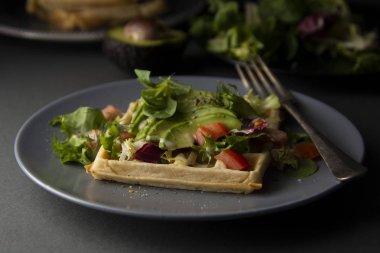 Avokado ve domates ile Belçikalı Waffle. Sağlıklı yiyecekler için mükemmel kahvaltı veya kilo.