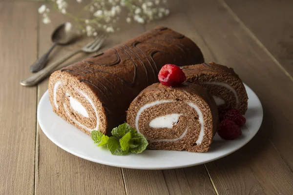 Heerlijke chocoladebroodspons cake met vanille room en muntblaadjes. Woestijnzoet voedsel. — Stockfoto