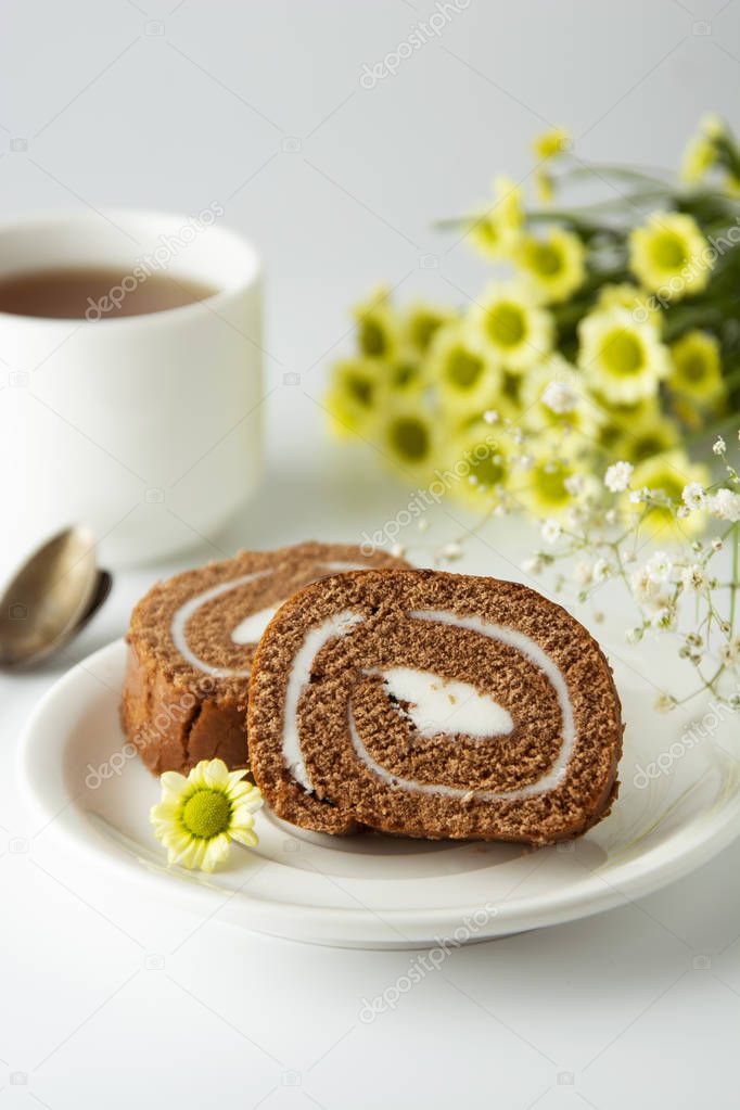 Swiss roll chocolate cake chocolate with cream. Dessert. Breakfast coffee cup and cake. Light background.