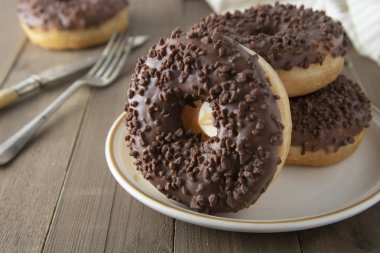 Çikolata Donuts kahvaltı veya tatlı, ahşap masa. Yakın cam çörekler. Tatlı yemek. Pasta.