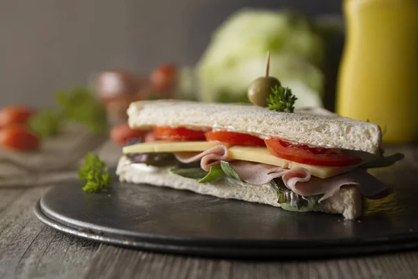 Homemade club sandwich. Toasted white bread triangles with ham, cheese fresh vegetables. Wooden table. — Stock Photo, Image