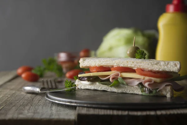 Sándwich de club casero. Triángulos de pan blanco tostado con jamón, verduras frescas de queso. Mesa de madera . — Foto de Stock